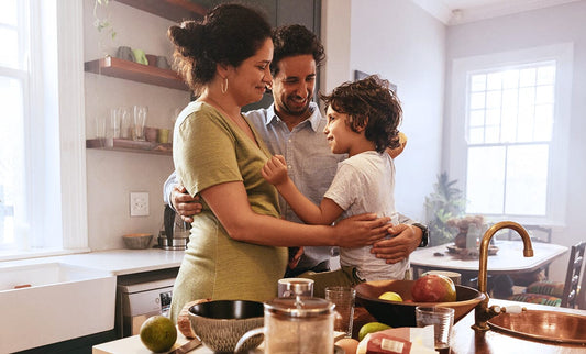 Mom Dad and Son in kitchen hugging