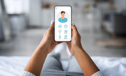 Woman on sofa holding phone with telehealth icon