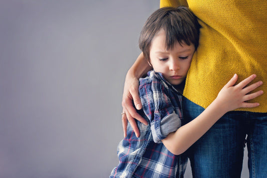 Young boy hugging his moms waist