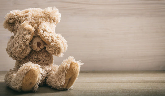 stuffed teddy bear covering it's eyes