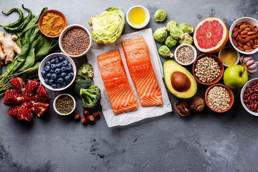Healthy foods laid out; blueberries, salmon, avocado etc.