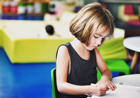 Young girl at school writing.