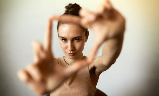 Woman making photo frame over face