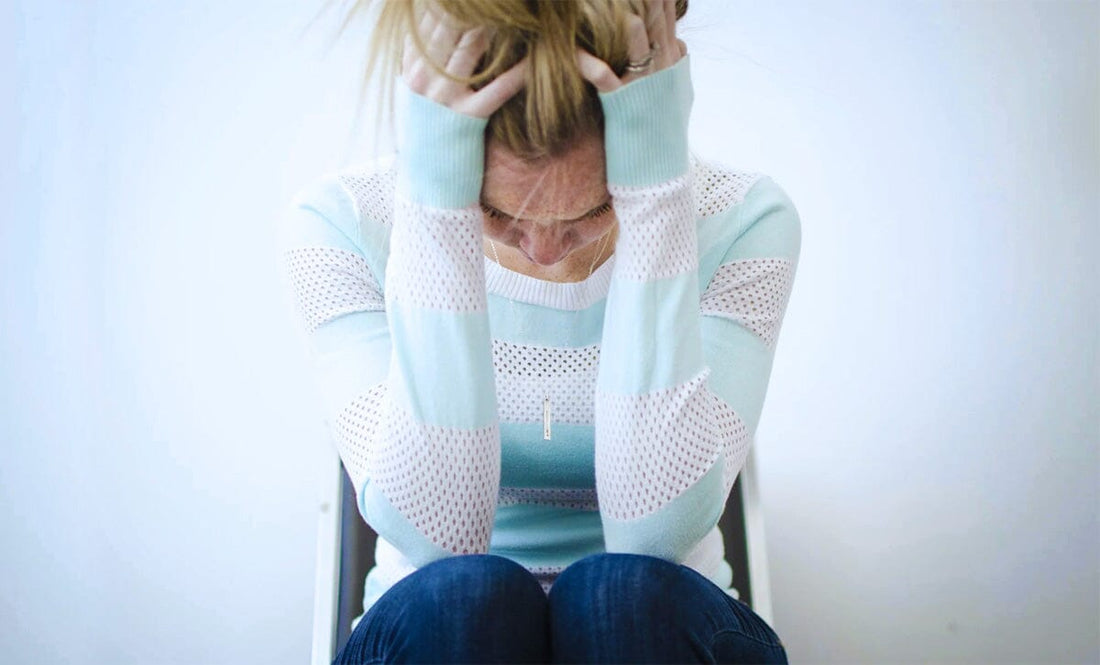 Woman in chair holding head