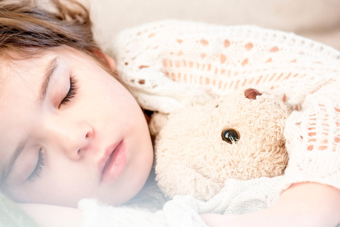 young girl sleeping with a teddy bear