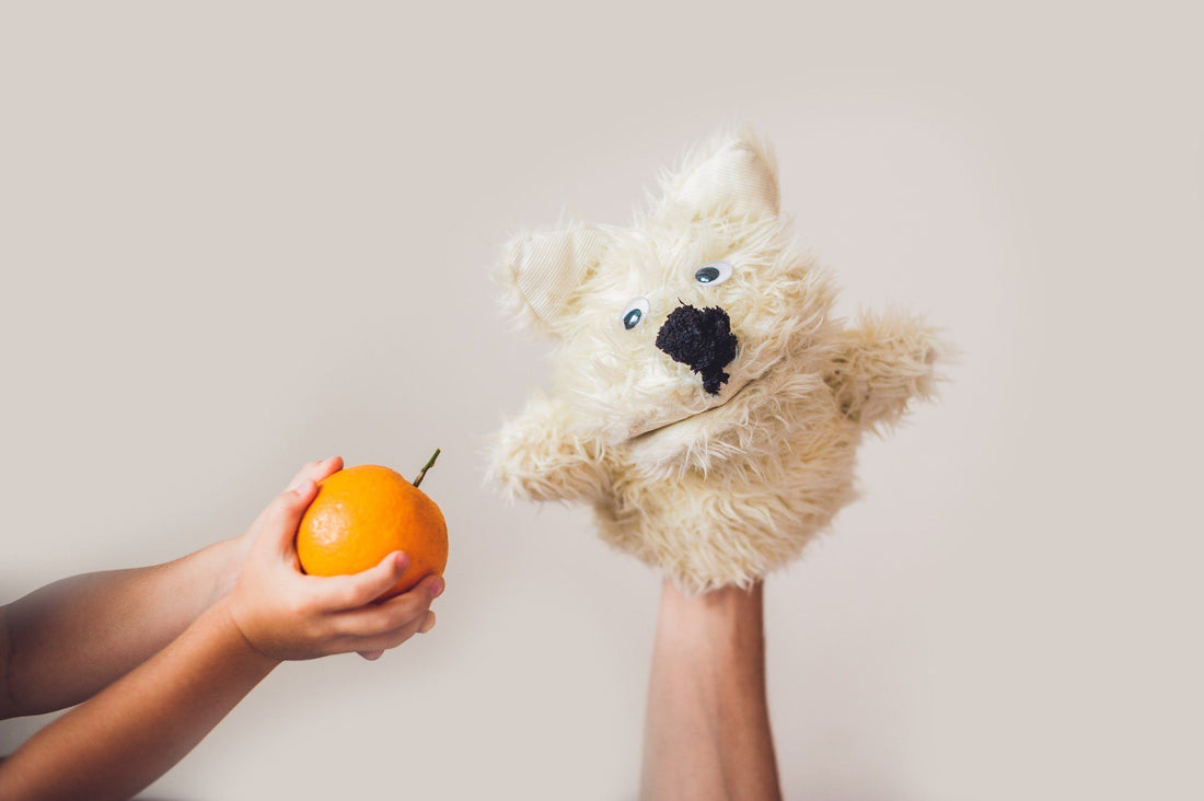 puppet with an orange next to it
