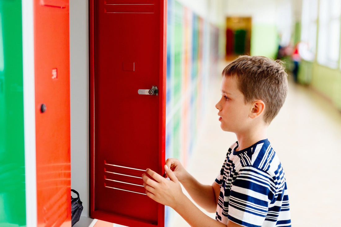 Adolescent boy standing at his locker